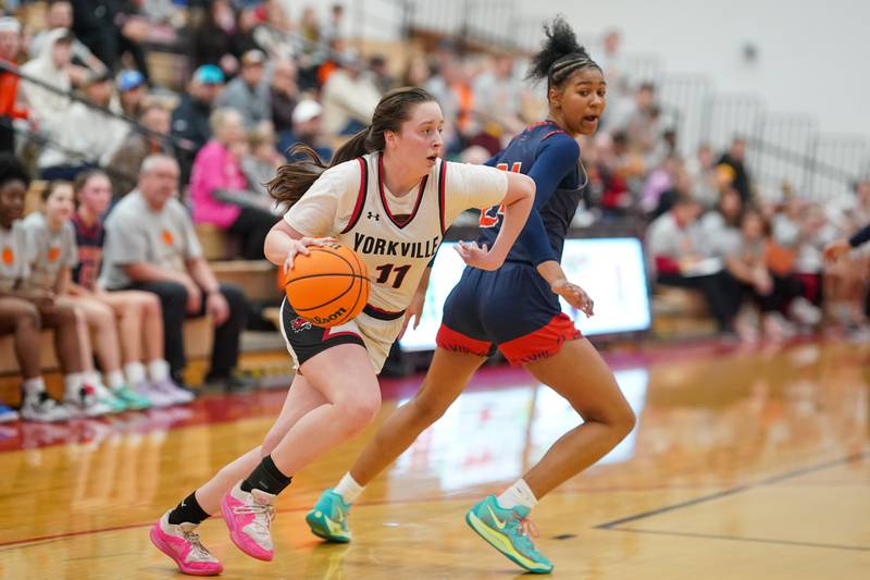 Yorkville's Brooke Spychalski (11) drives to the hoop against Oswego's Peytton Wiggins (24) during a hoops for hope basketball game at Yorkville High School on Saturday, Feb. 8, 2025.