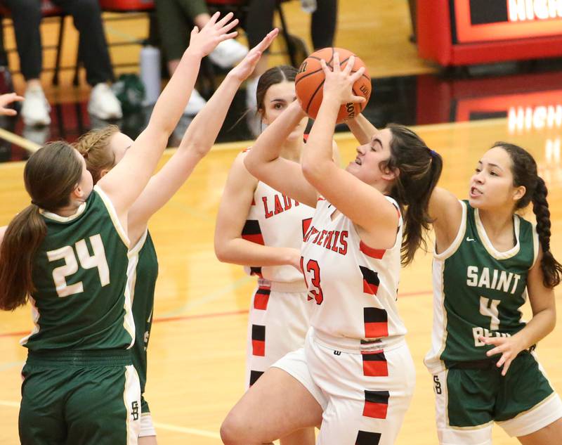 Hall's Mckenna Christiansen (13) dribbles into the lane past St. Bede's Marly Tillman (24) and Kristal De La Torre (4) to score a basket on Monday, Nov. 28, 2022 at Hall High School in Spring Valley.