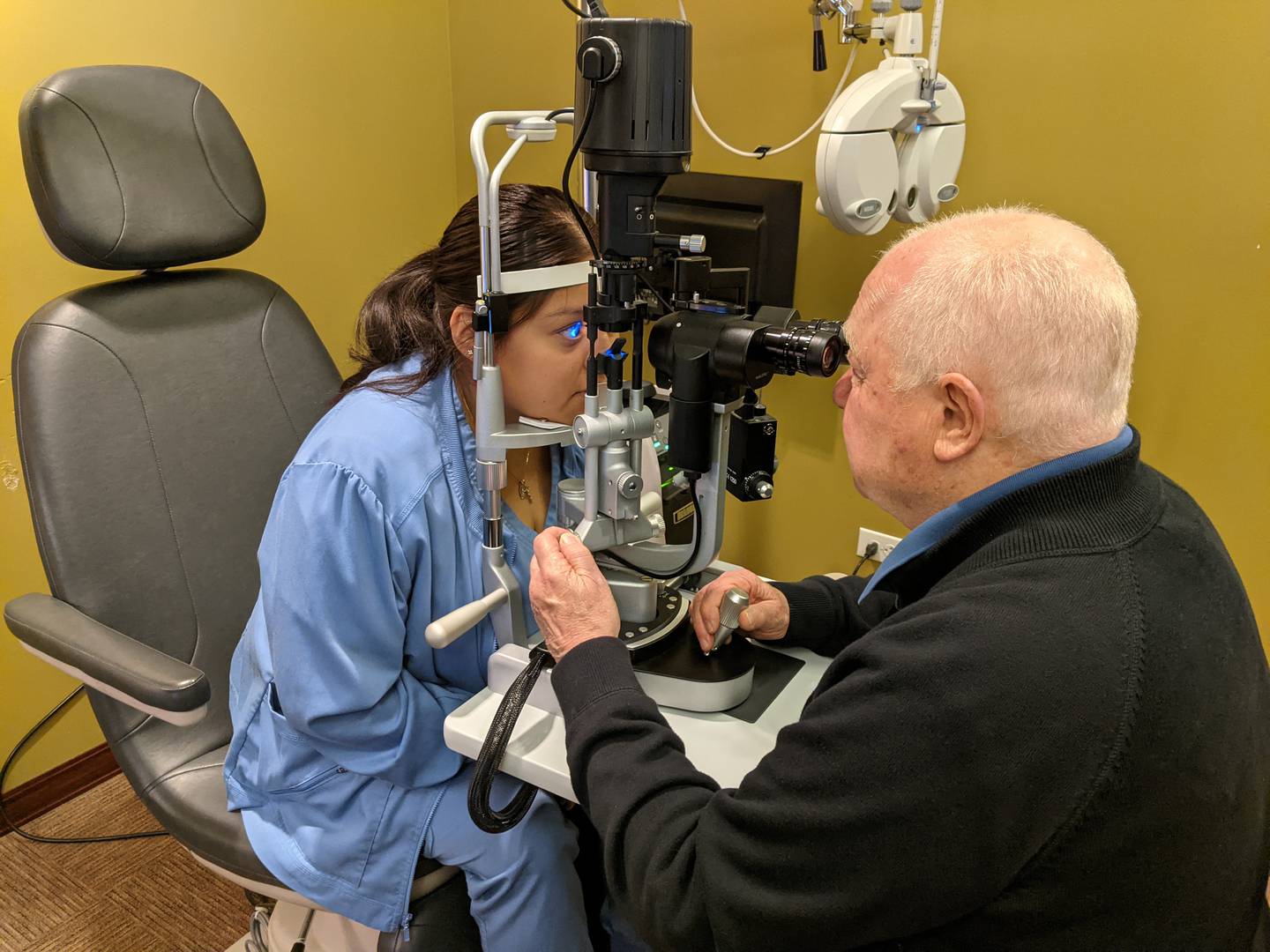 Optometrist Ronald Weingart examines the eyes of Scott Eye Care optical technician Selene Jimenez.