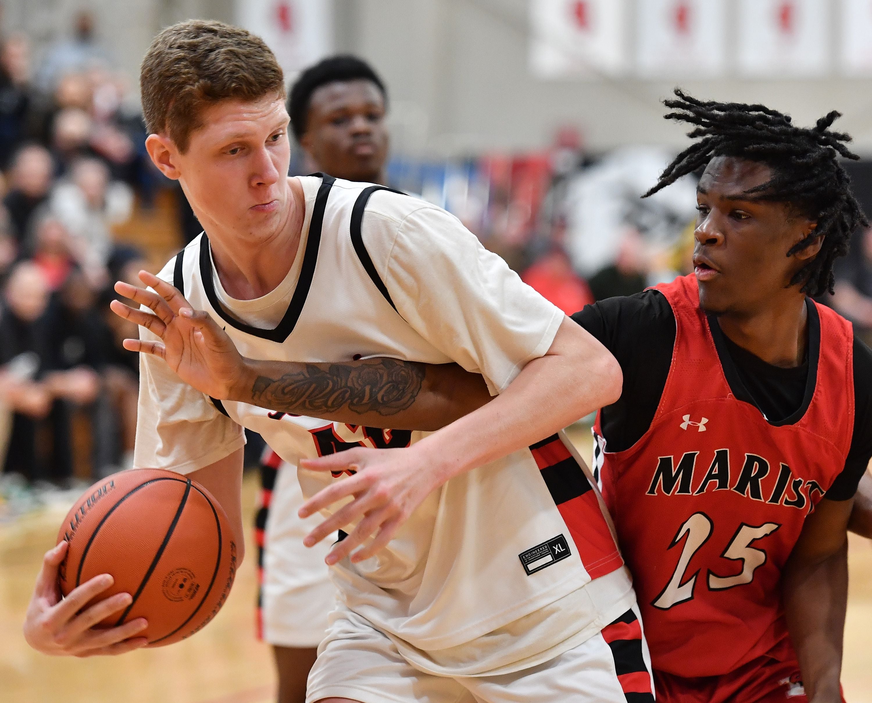 Benet's Colin Stack is fouled by Marist's Marquis Vance (25) during a game on Dec. 15, 2023 at Benet Academy in Lisle.