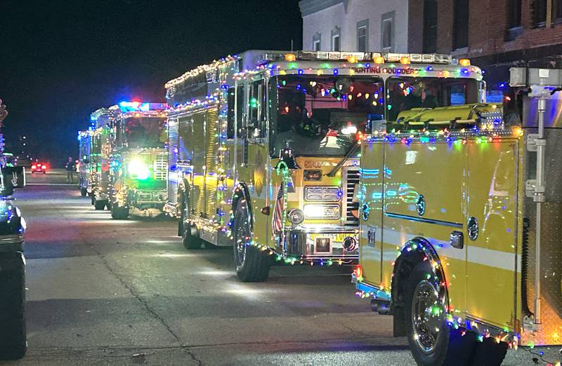 Mt. Morris fire engines and trucks lined up on Wesley Ave. during the lighted parade at Mt. Morris' Christmas in the Village on Saturday, Dec. 7, 2024.