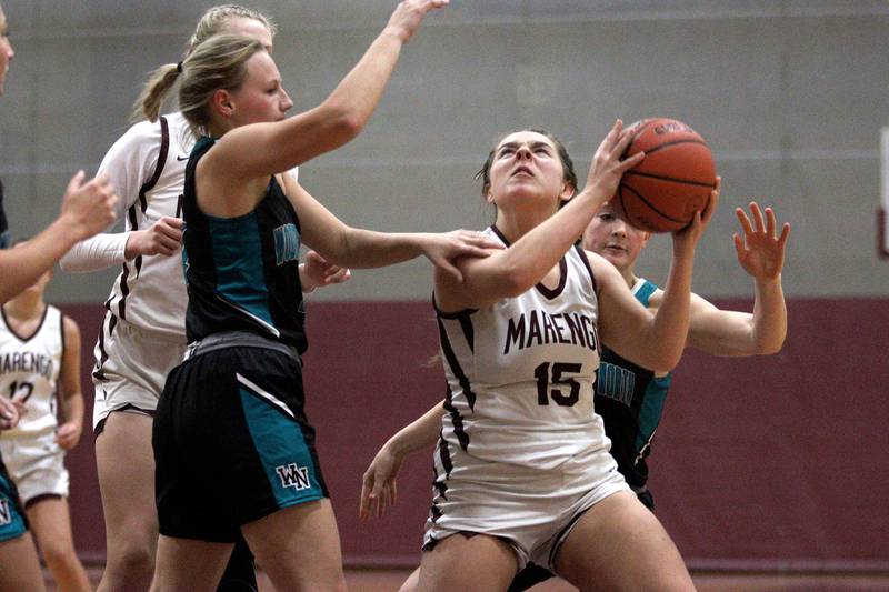 Marengo’s Emilie Polizzi works under the hoop against Woodstock North in varsity girls basketball at Marengo Tuesday evening.
