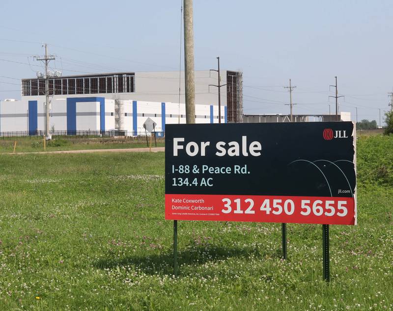 A for sale sign at the northeast corner of Peace Road and East Gurler Road with the Kraft Heinz Company distribution center on the nothwest corner in the background Friday, July 12, 2024, in DeKalb.