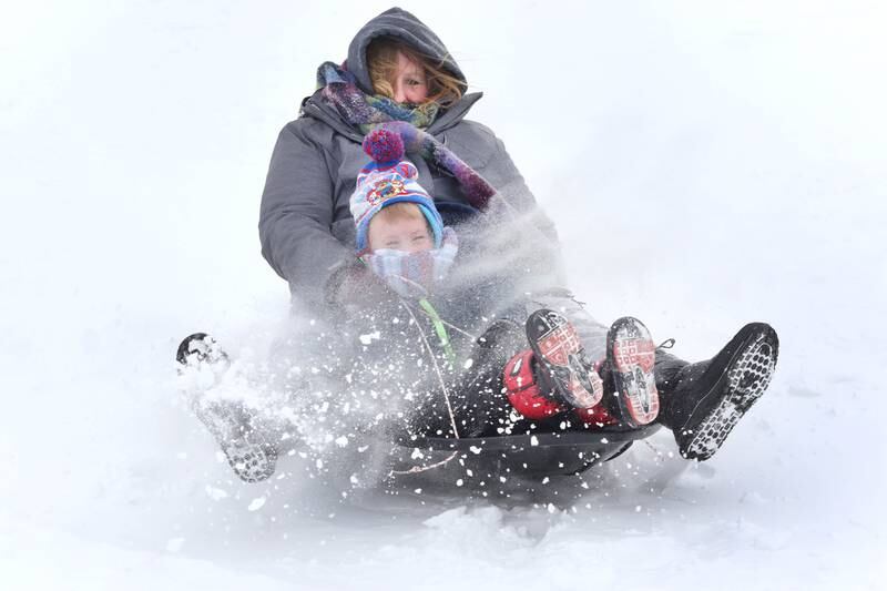 Karen Rott, and her son Ian, 4, from Leland, kick up some snow as they sled down the hill Wednesday, Feb. 2, 2022, at the Sycamore Park District Community Center. Snow fell overnight and into Wednesday across DeKalb County.