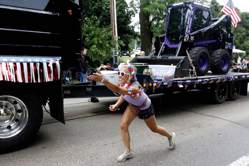 Bailey Hall tosses candy Sunday, July 2, 2023 during Crystal Lake’s annual Independence Day Parade on Dole Avenue in Crystal Lake. This year’s parade feature close to 100 units.