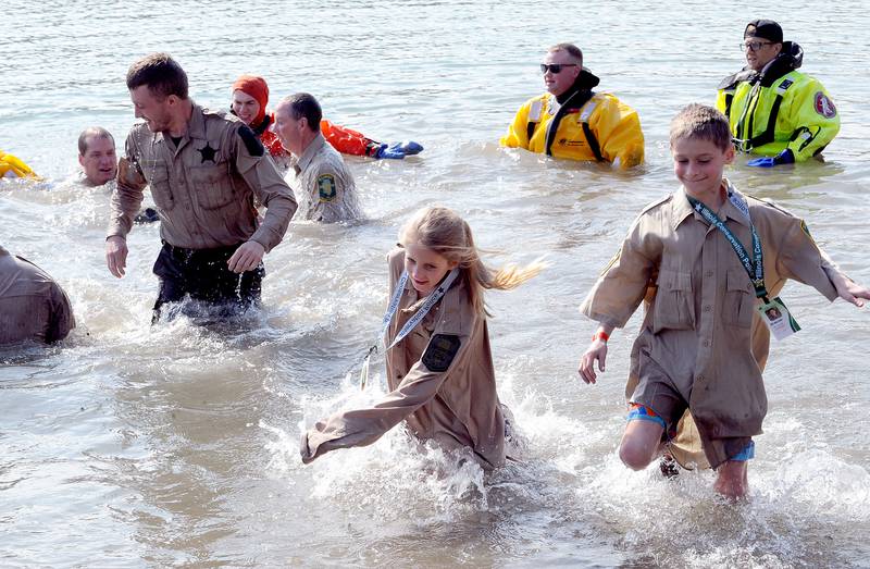 Members of the Illinois Conservation Police and their families emerge from the water during the annual Polar Plunge to support Special Olympics Illinois at Siver Springs State Park's Loon Lake on Sunday, Mar. 5, 2023.